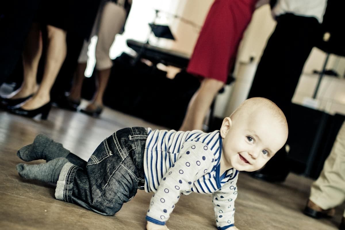 Litet barn som kryper i kök mot skåp med barnspärr